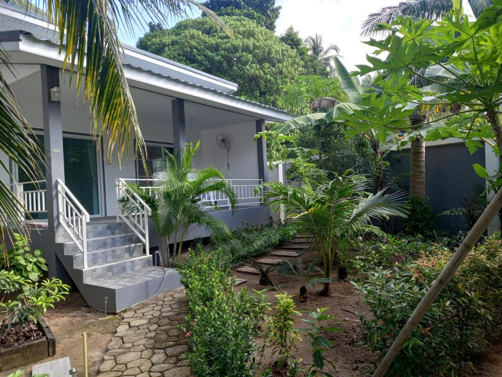 una casa con escaleras y plantas delante de ella en sweet home phangan, en Srithanu