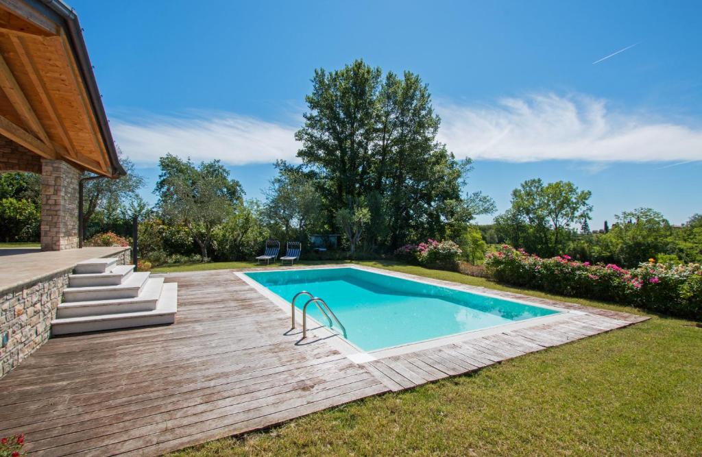 Villa Marina con piscina by Wonderful Italy في سويانو ديل لاغو: مسبح في ساحة وسطح خشبي
