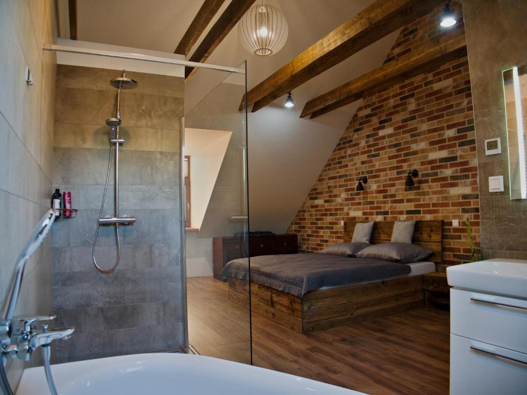 a bathroom with a shower and a bed in a room at Apartman Vulcano in Zvolen