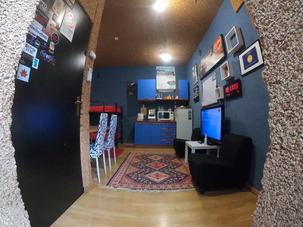 a living room with a blue wall and a tv at Dépendance ai piedi dalla Majella in Raiano