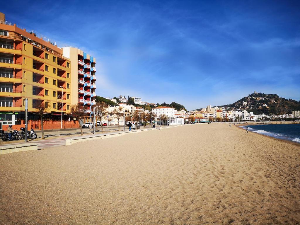 a view of a beach with buildings and the ocean at Apartamentos Elvira in Blanes
