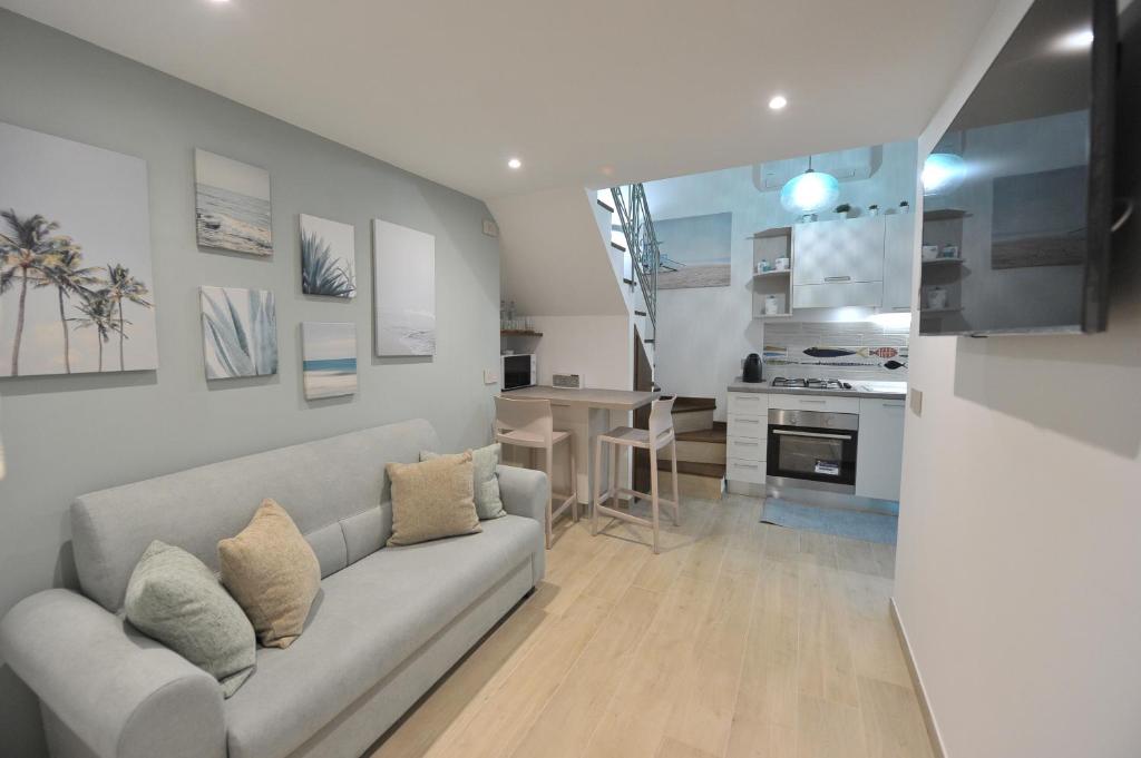 a living room with a couch and a kitchen at Little Dream in Piano di Sorrento