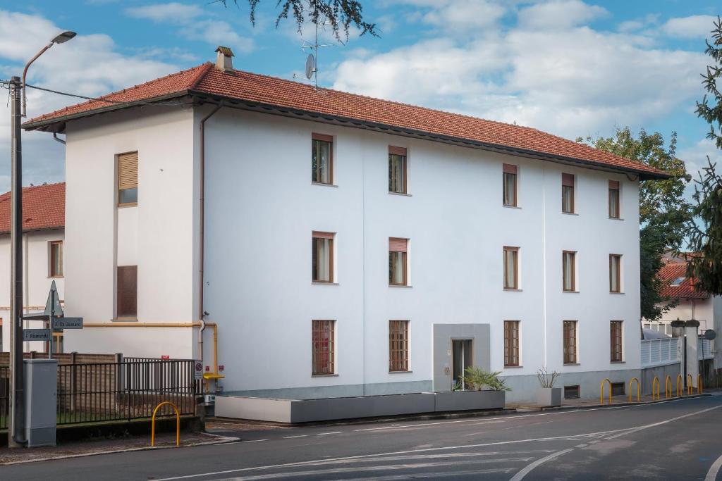 a white building with a red roof on a street at Pasta Residence Italia Malpensa in Gallarate