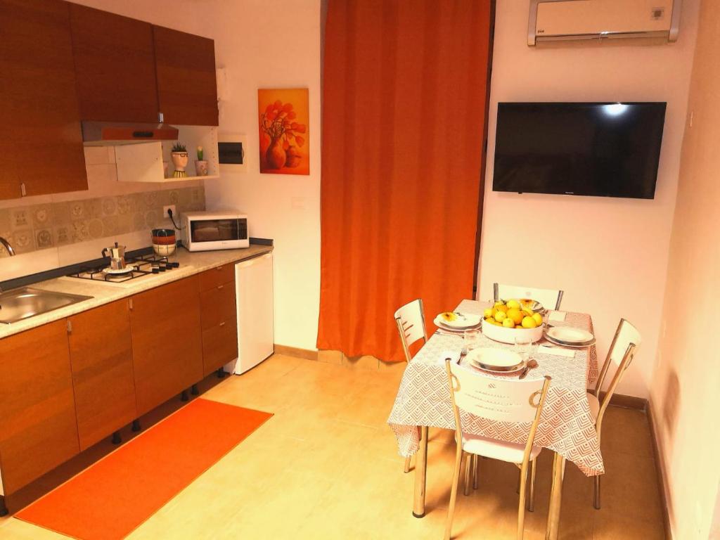 una cucina con tavolo e sedie e una cucina con tavolo e cucina di CASA QUIDERA LOCAZIONE TURISTICA / AFFITTI BREVI a Castelvetrano Selinunte