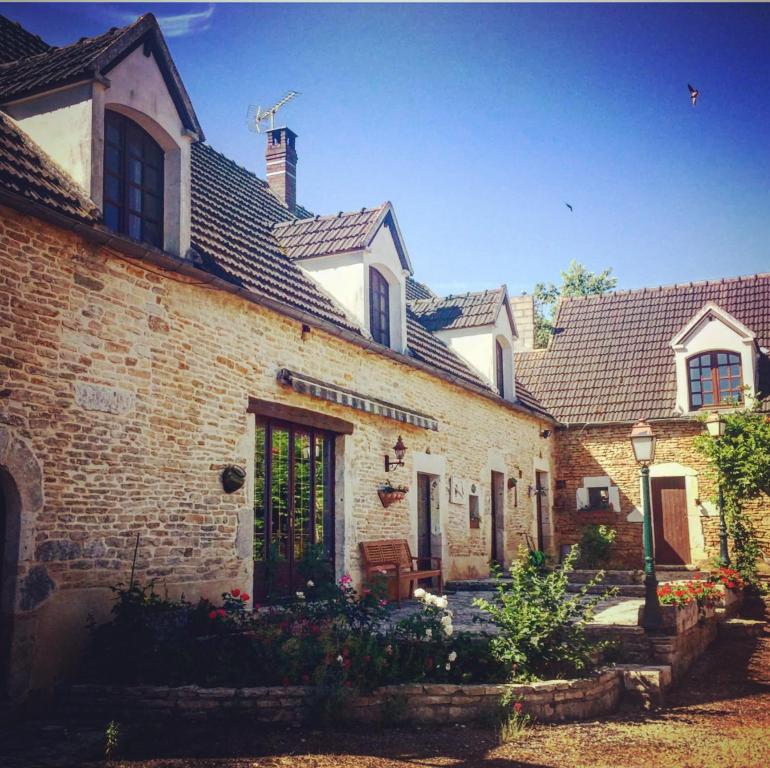 Avrigny的住宿－Gîte du ru d ausson，一座老砖房子,有一扇门和一个院子