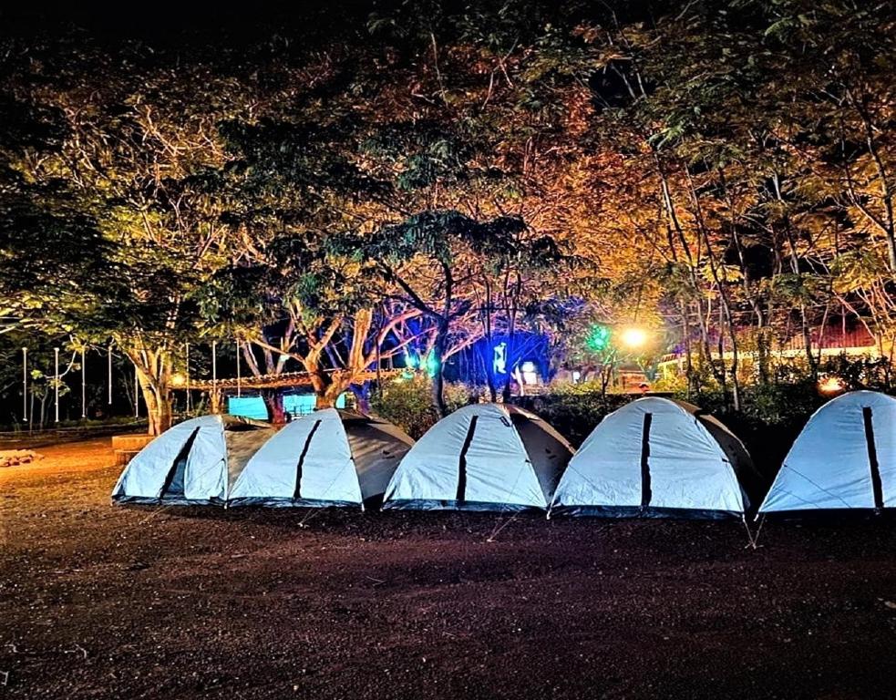 a group of tents in a field at night at StayApart - Deccan Trails Vikarabad in Vikārābād