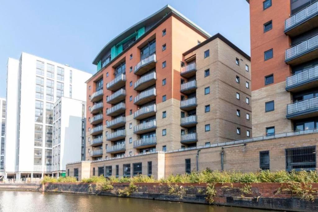 ein hohes Gebäude neben einem Fluss mit Gebäuden in der Unterkunft Empire Serviced Apartments in Leicester