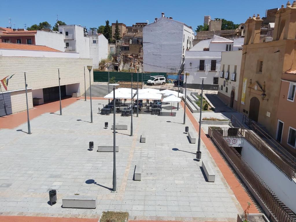 un patio con mesas y sombrillas en una ciudad en Apartamento Turismo Badajoz, en Badajoz