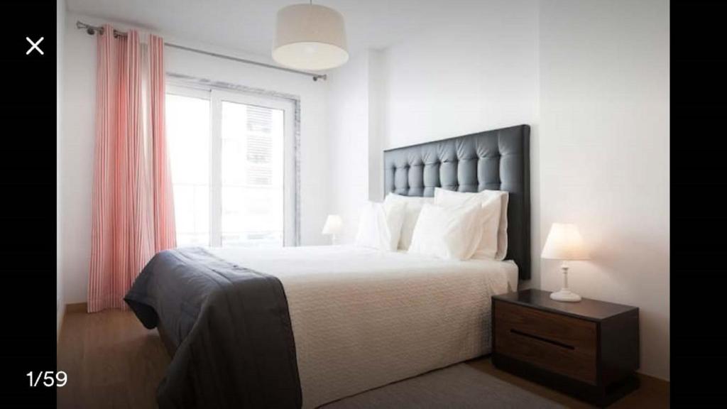 a bedroom with a large bed and a window at Modern Apartment for Family and Group of Friends in Sacavém