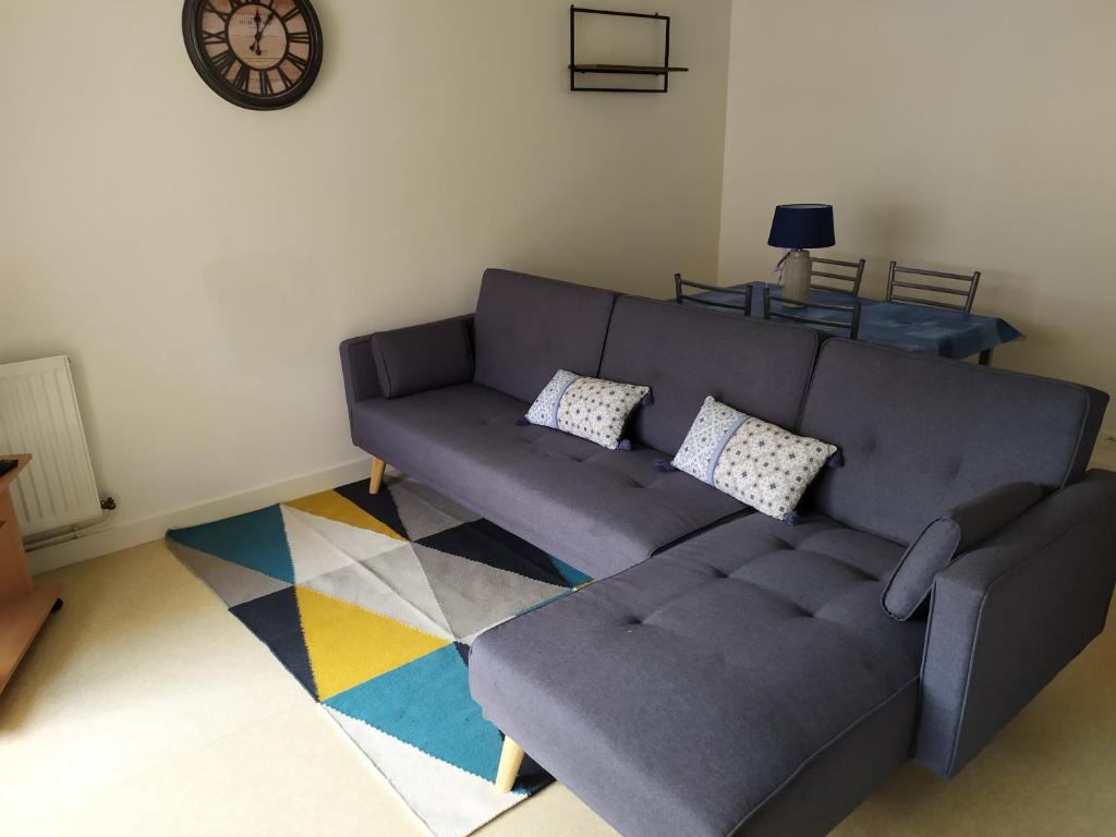 - un salon avec un canapé gris et un tapis dans l'établissement T1 Bis Cosy avec 6 couchages proche de la mer - Quartier Minimes, à La Rochelle