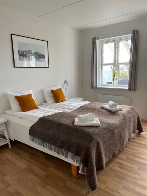 a bedroom with a large bed with two towels on it at Hotel Nygaard Læsø in Byrum