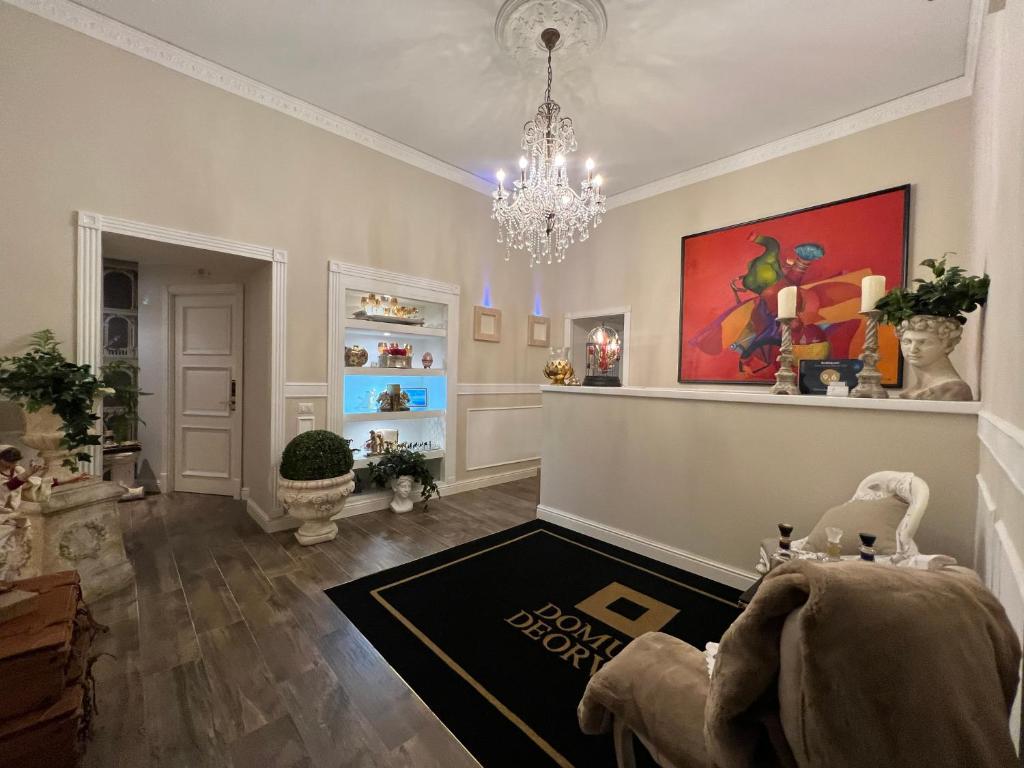 a living room with a chandelier and a rug at Domus Deorum Deluxe in Naples