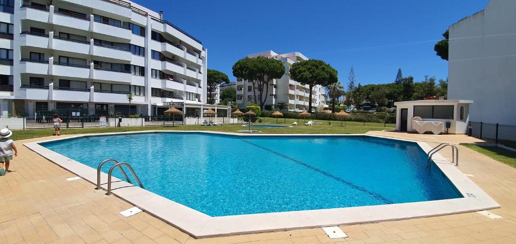a large swimming pool in front of a building at Golf & Mar - T2 Apartment in Vilamoura
