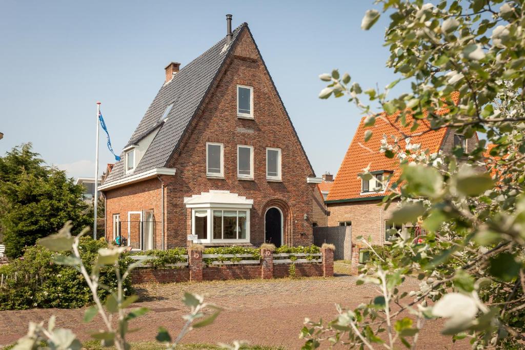 une maison en briques avec un toit en gambrel dans l'établissement Vakantiehuis Zeevonk, à Bergen aan Zee