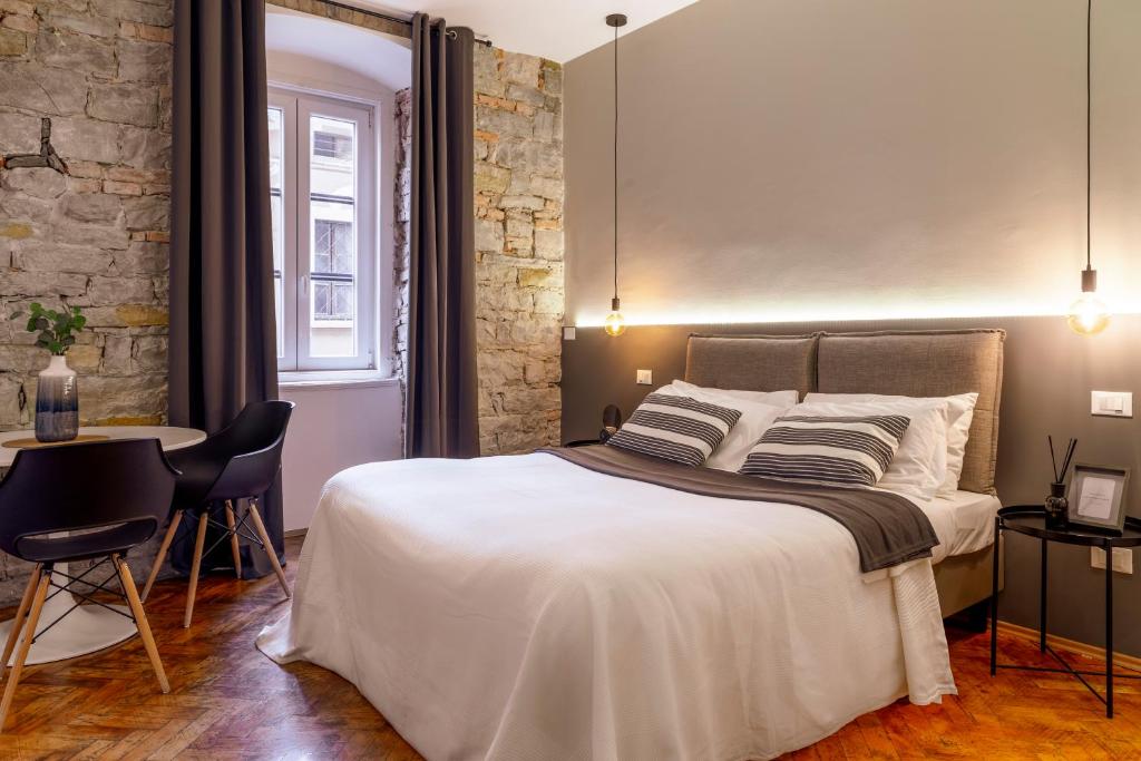 Schlafzimmer mit einem Bett, einem Tisch und Stühlen in der Unterkunft Romantic studio in the heart of Trieste in Triest