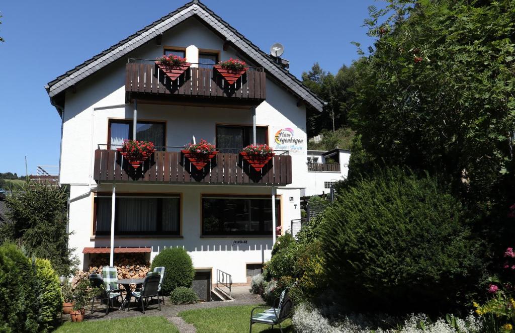 a white building with flowerpots on the balconies at Aktivpension Regenbogen in Willingen