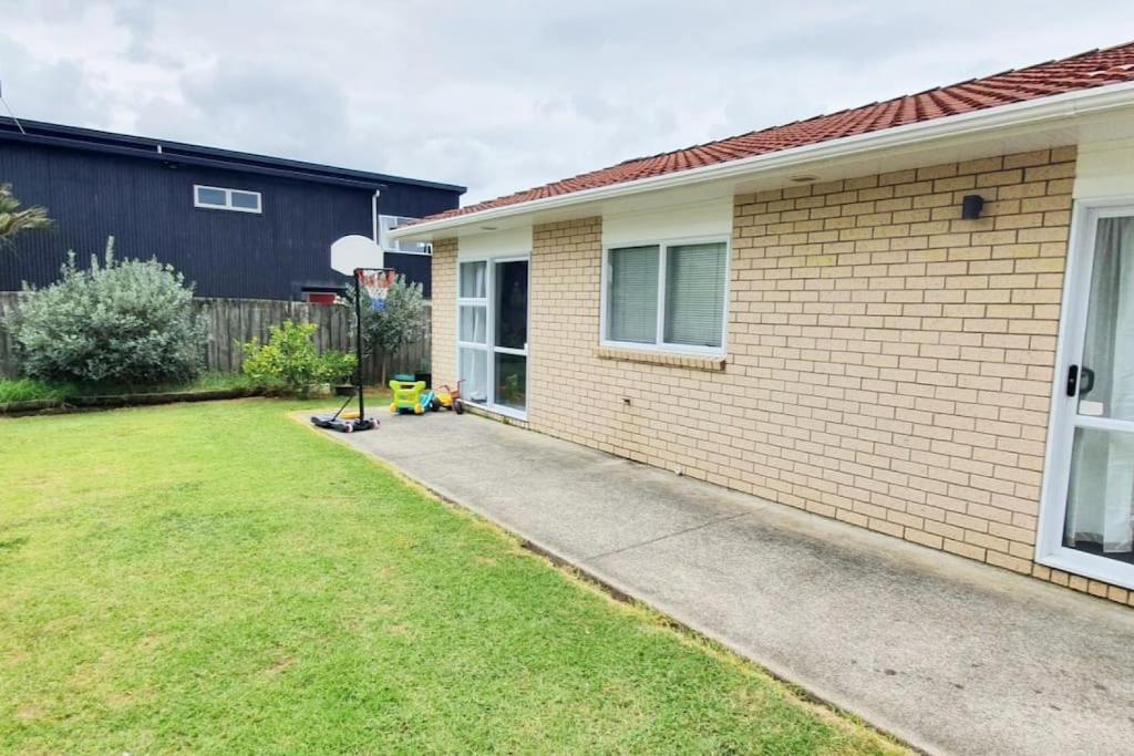 a backyard of a house with a driveway at Cheerful 3BR Home With Free WiFi & Netflix in Auckland