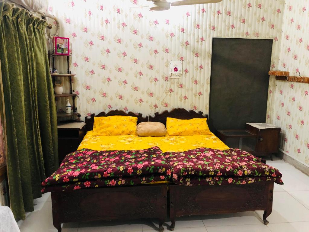 Un dormitorio con una cama con flores. en Al-Noor Cottage en Rawalpindi
