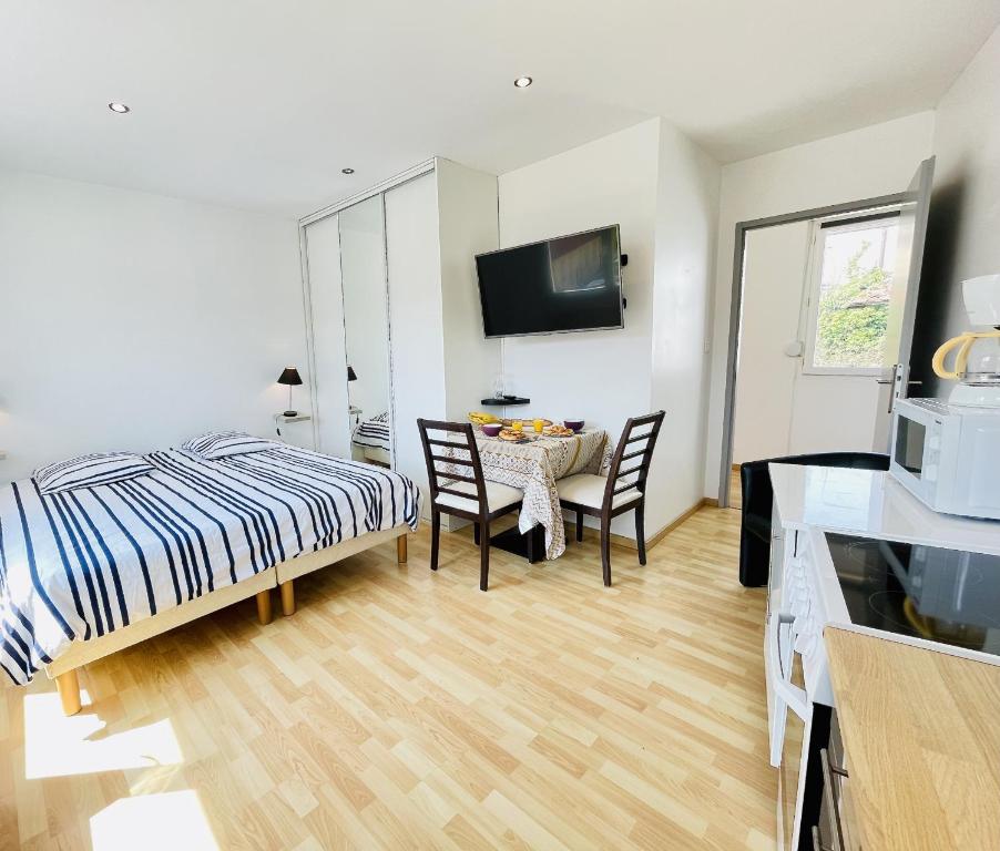 1 dormitorio con 1 cama, mesa y sillas en Residence Louis Place du Marche en Bains-les-Bains