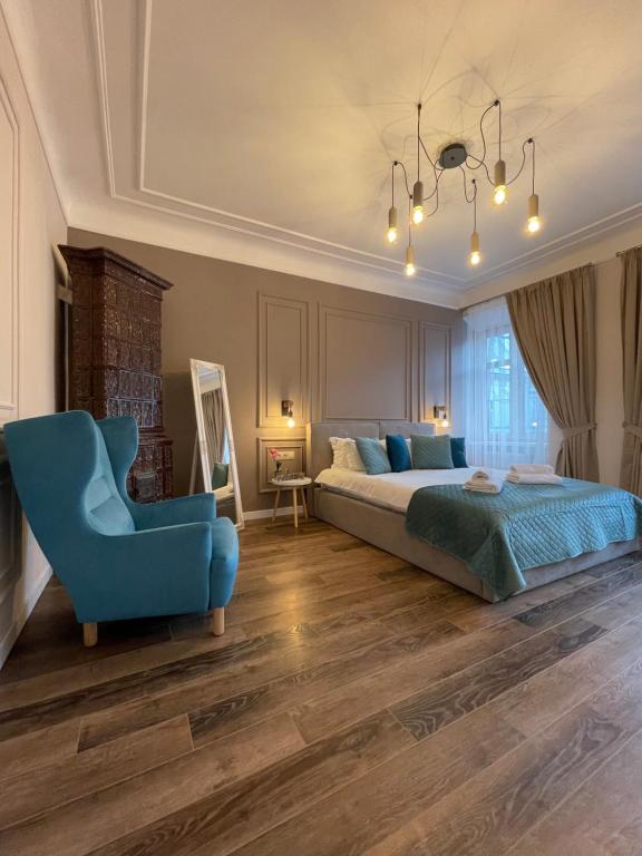 1 dormitorio con 1 cama y 1 silla azul en Von Cruss apartments in Lviv, en Leópolis