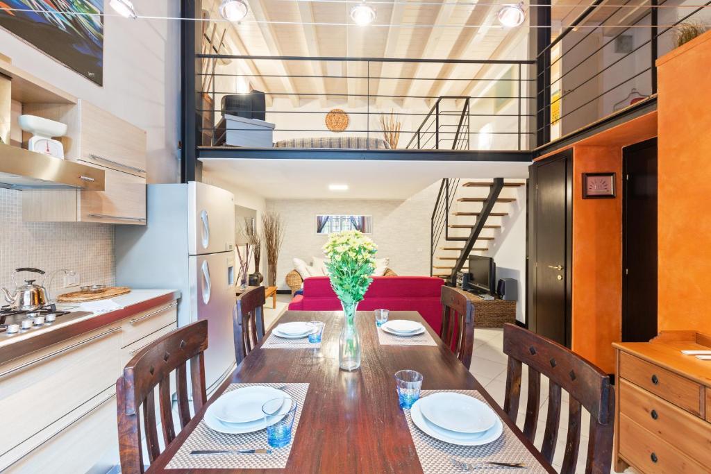 a dining room with a table and a red couch at Loft di Design Porta Romana/Corso Lodi in Milan