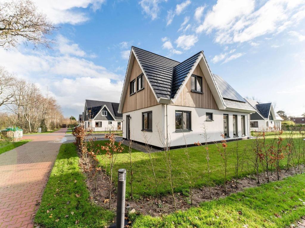 a white house with a black roof at Serene Holiday Home in De Koog Texel with Sauna in Westermient