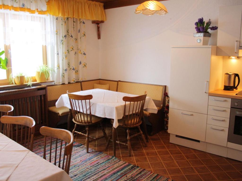 a kitchen with a table and chairs in a room at Apartment in Taxenbach with Garden Garden Furniture BBQ in Taxenbach
