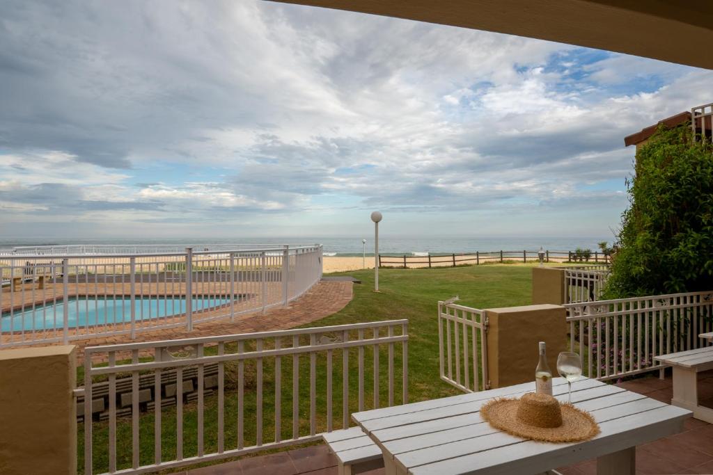 a balcony with a table and a view of the beach at Jeffreys Bay Villas on The Beach in Jeffreys Bay
