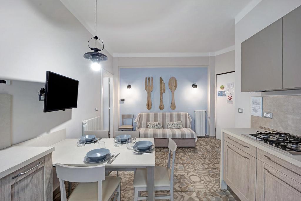een keuken met een tafel en een woonkamer bij Victoria Apartments Maiolica in Diano Marina