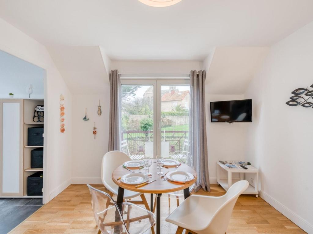 uma sala de jantar com mesa e cadeiras em Apartment in a residence by the sea em Port-en-Bessin-Huppain