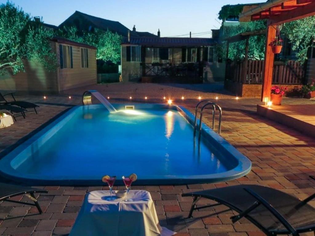 una piscina in un cortile posteriore di notte di Captivating Holiday Home in Pako tane with Swimming Pool a Pakoštane
