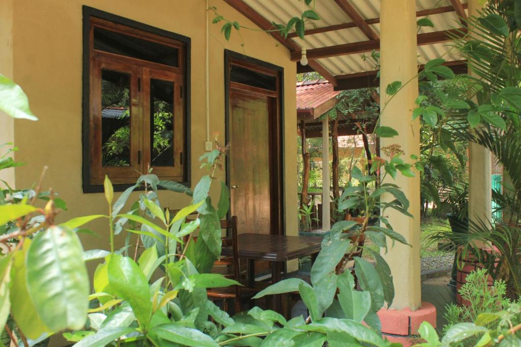 eine Veranda eines Hauses mit einem Tisch und einigen Pflanzen in der Unterkunft Sigiri Serenity Homestay in Sigiriya