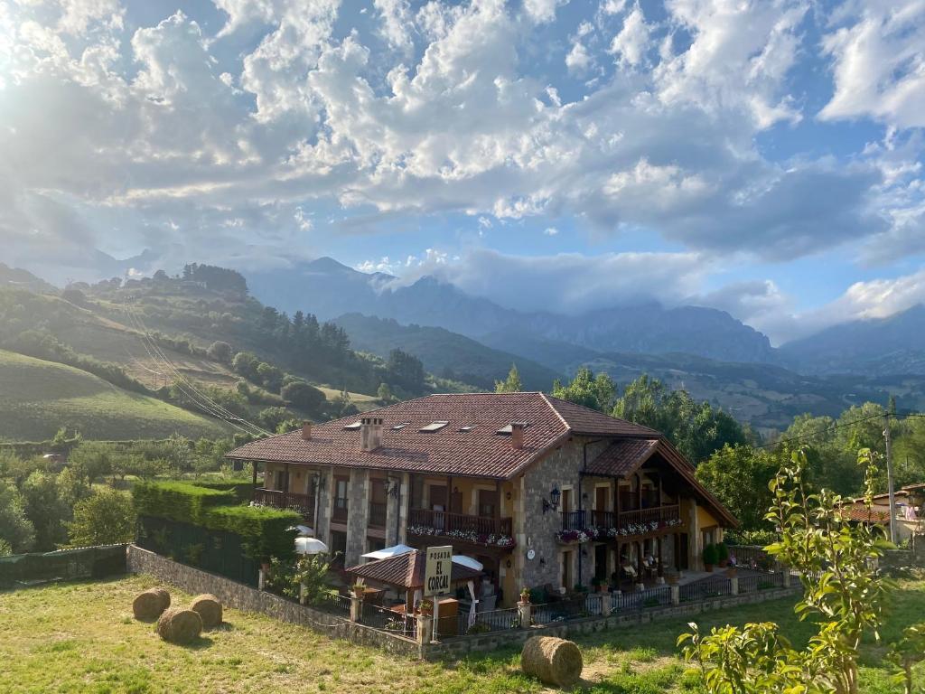 a house on a hill with mountains in the background at Posada El Corcal de Liébana in Tama