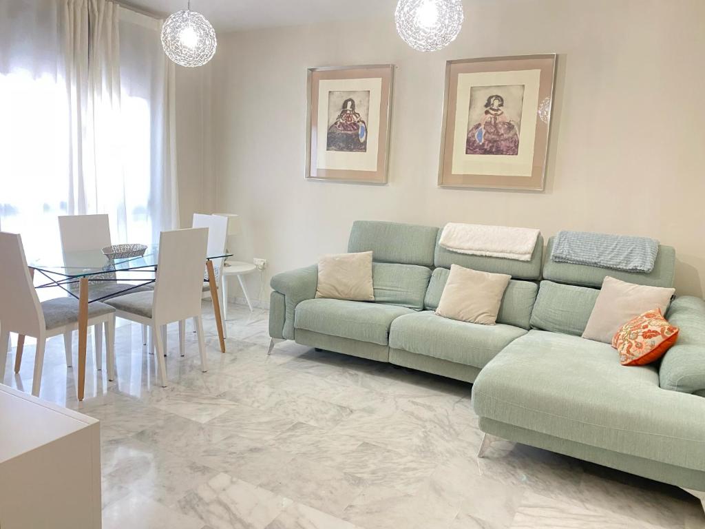 a living room with a green couch and a table at Apartment Lucena Center Atico in Lucena