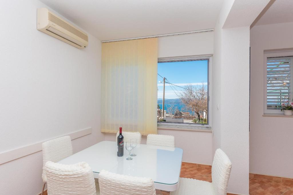 ein weißes Esszimmer mit einem weißen Tisch und Stühlen in der Unterkunft Apartment Ana Chill in Bast in Bast