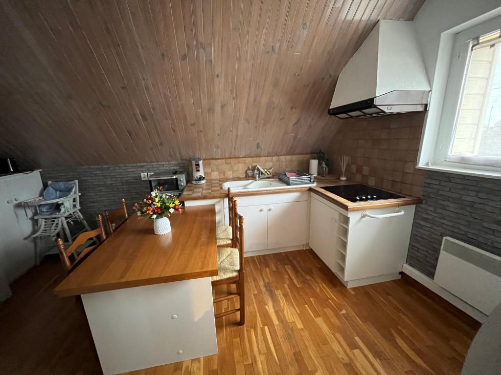 une cuisine avec des armoires blanches et un plancher en bois dans l'établissement LE RAYON DE SOLEIL, à Froberville