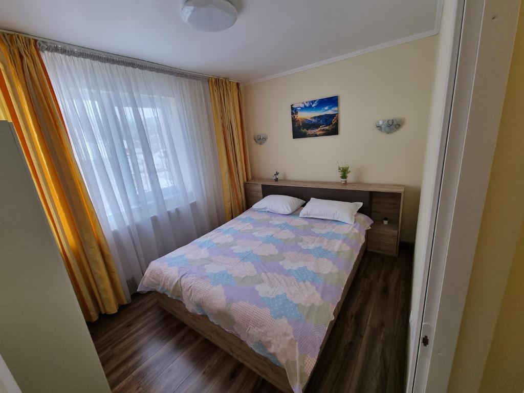 a small bedroom with a bed and a window at 11 RESIDENCE APARTMENT in Cavnic