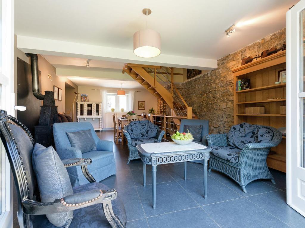 uma sala de estar com cadeiras azuis e uma mesa em Blissful holiday home in Sprimont with sauna em Damré