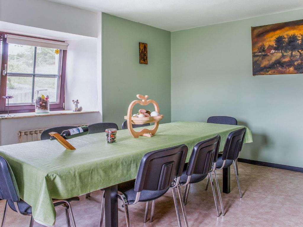 een eetkamer met een groene tafel en stoelen bij Holiday Home near Ravel Cycling paths in Heuem