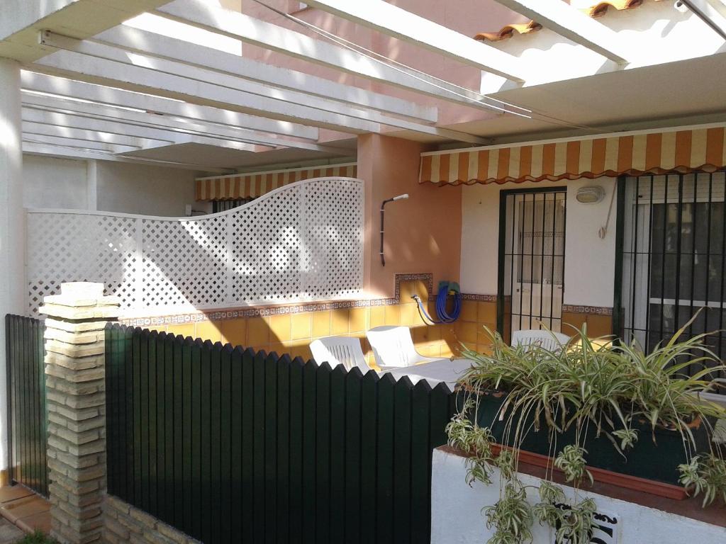 a room with a fence and chairs and a building at Primera línea de playa casita adosada in Chiclana de la Frontera