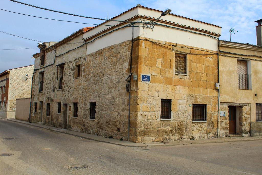 un vieux bâtiment en briques situé sur le côté d'une rue dans l'établissement CASA RURAL LAS BODEGAS, à Valbuena de Duero