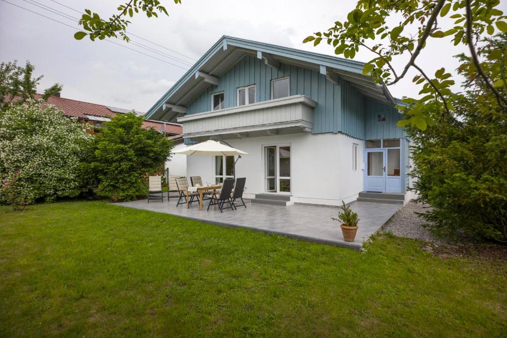 uma casa com um pátio com uma mesa e cadeiras em Landhaus Kaiserblick em Oberaudorf