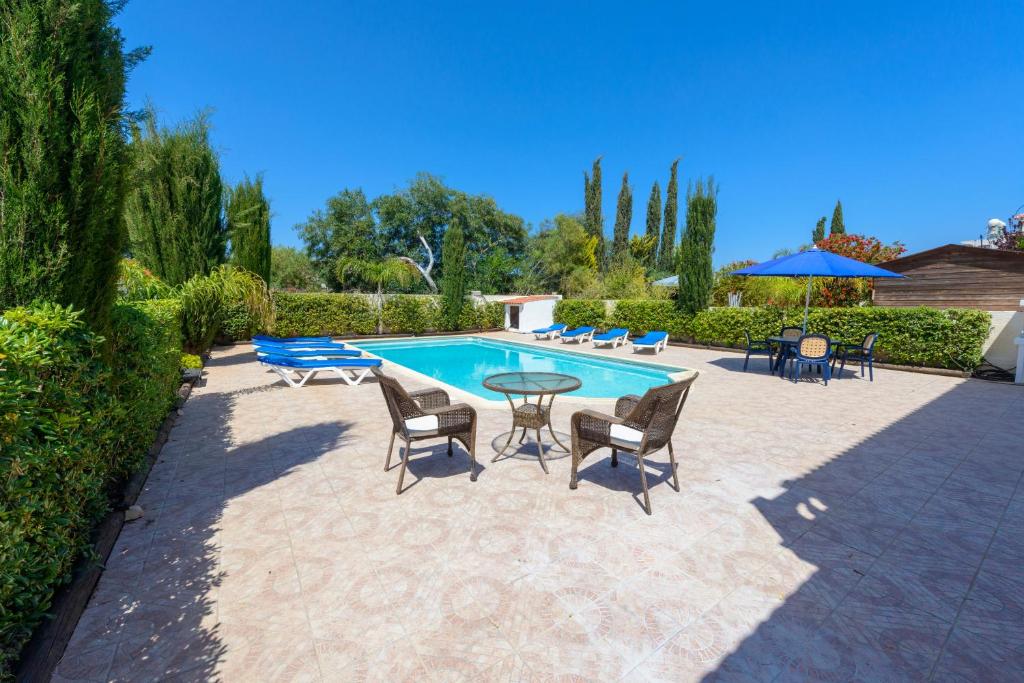a patio with a table and chairs and a pool at Villa Sam in Ayia Napa