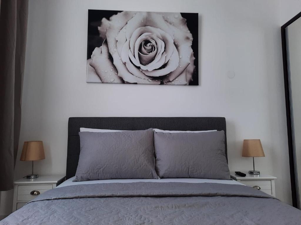 1 dormitorio con 1 cama con una flor en la pared en Luxury City Center Apartment – Garofita Romana, en Bucarest