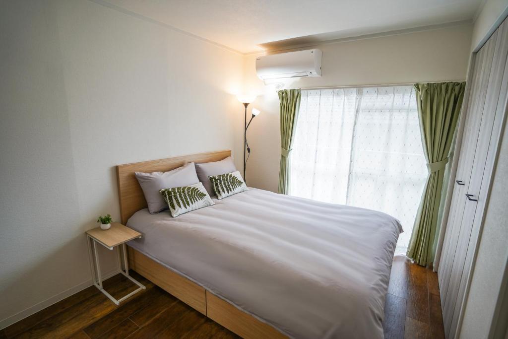 1 dormitorio con 1 cama blanca grande y ventana en stay's サンジョイフル 304号 名古屋 民泊 駅近 en Nagoya