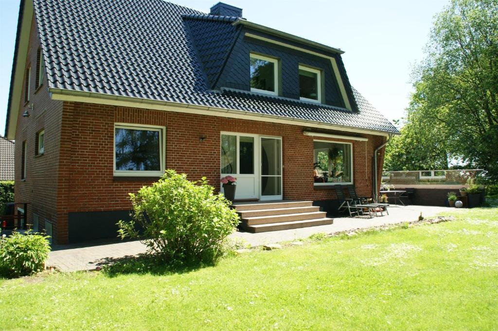 a small brick house with a black roof at Ferienwohnung Storchennest in Hürup