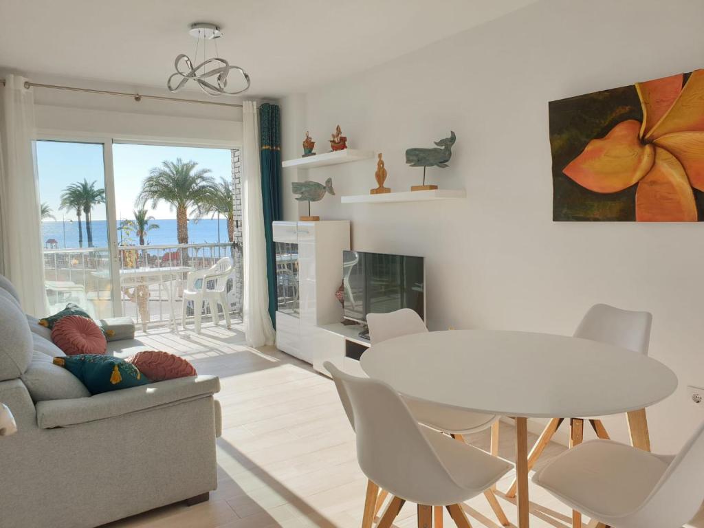 un soggiorno con tavolo, sedie e vista sull'oceano di Mirando al Mar desde el Rihuete a Puerto de Mazarrón
