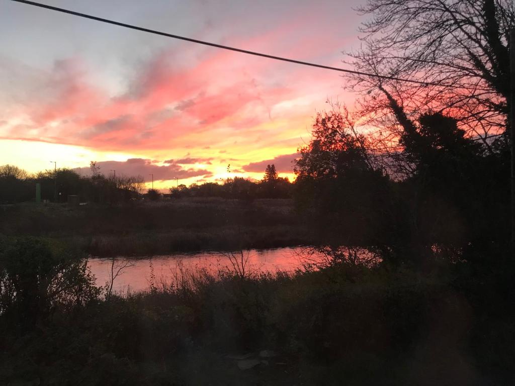 a sunset over a body of water with the sky at The TollHouse in Stirling