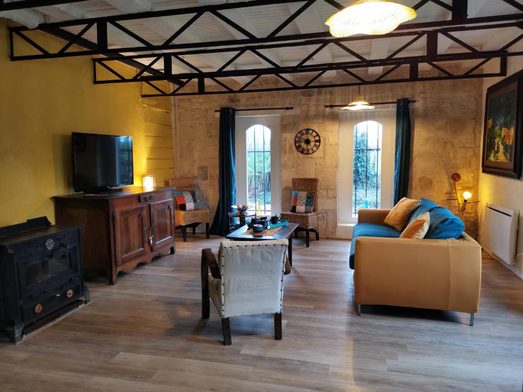 a living room with a couch and a tv at Warm 2 bedroom stone house with garden - Dodo et Tartine in Saint-Sigismond