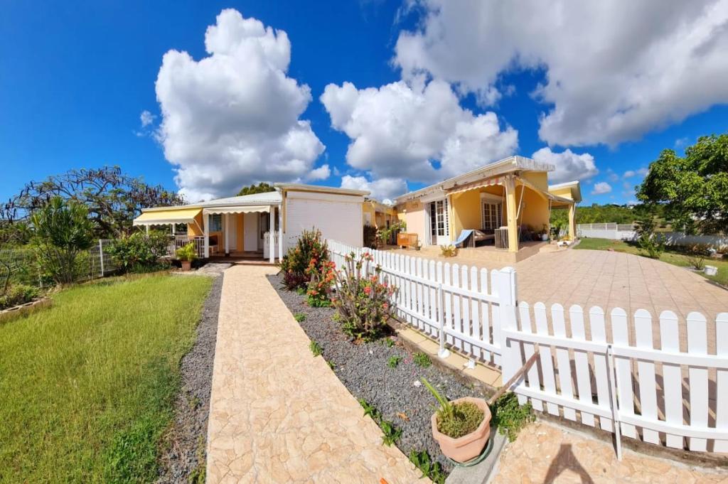 a house with a white picket fence at LOUE F3 VUE SUR MER DANS PROPRIETE PRIVEE in Sainte-Anne